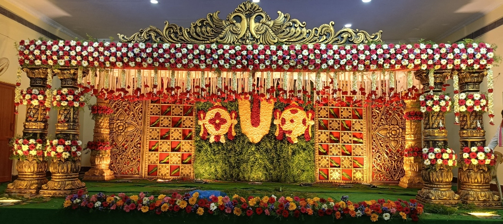 Grand Golden Carved Temple Wedding Mandapam with Fresh Flowers in Vijayawada